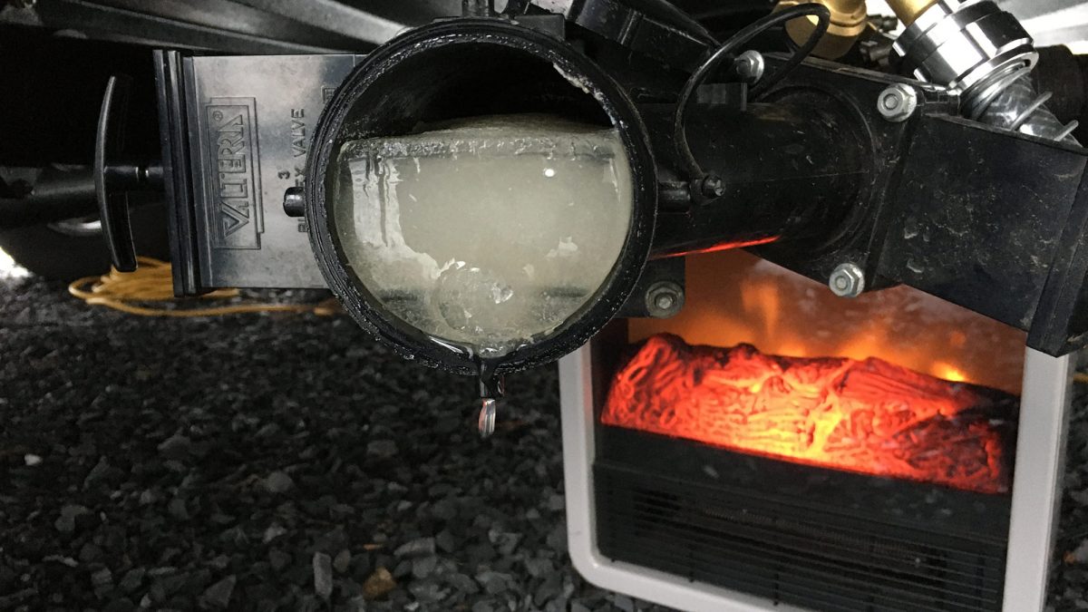 Sewer pipe (and contents) frozen solid under camper in winter weather.