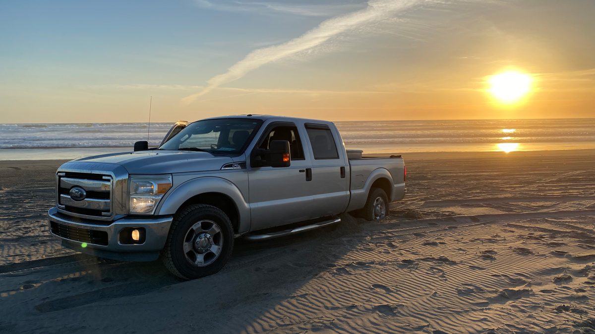 F250 thoroughly stuck in the sand on an Oregon beach.