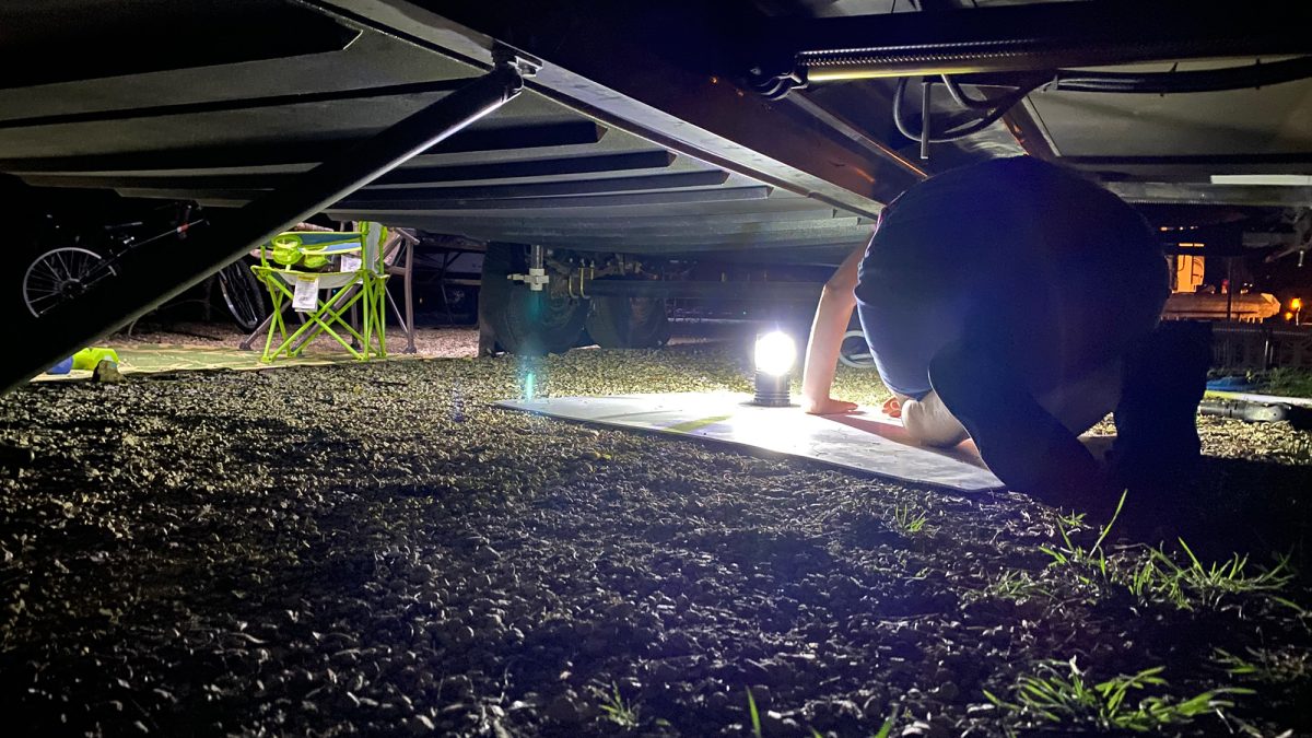 Inspecting the camper underbelly, which is cracked and falling out.