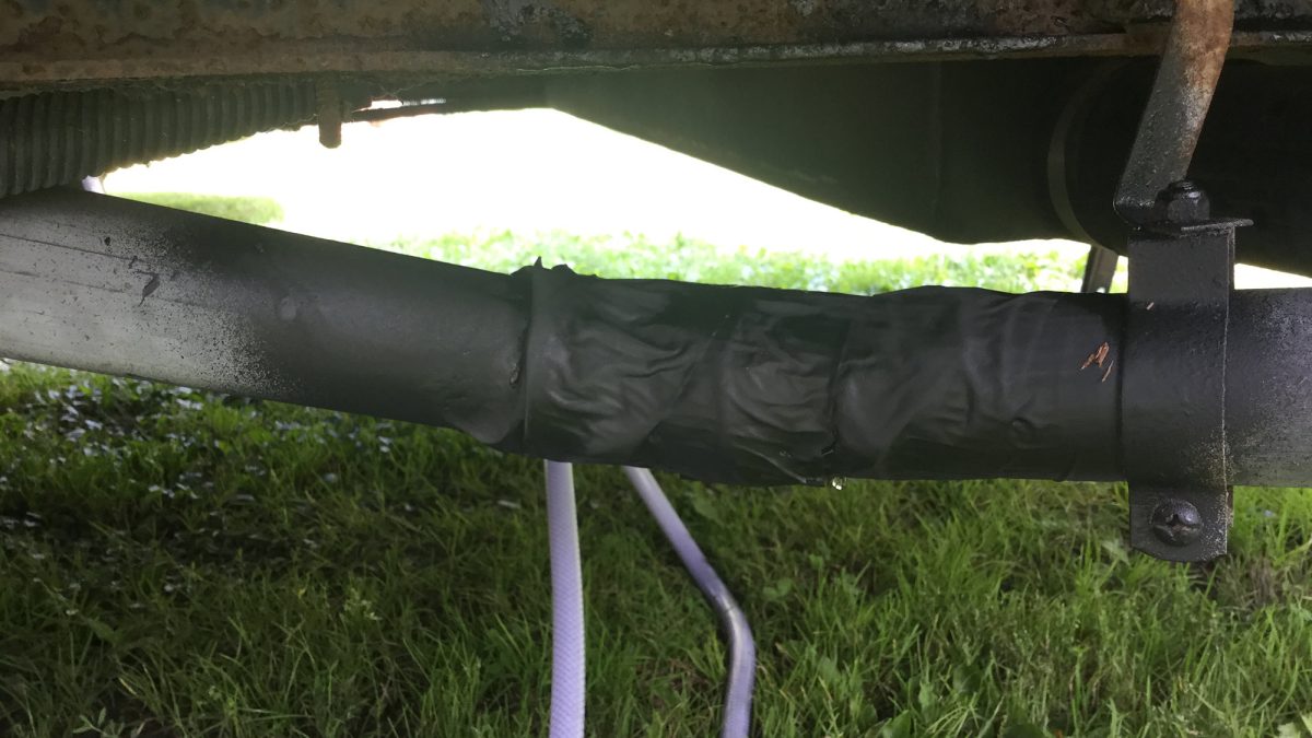 A broken camper drain pipe temporarily reconnected using Flex Seal.